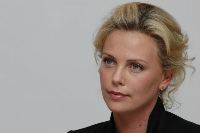 woman wearing black collared top Charlize Theron actress looking away 2k