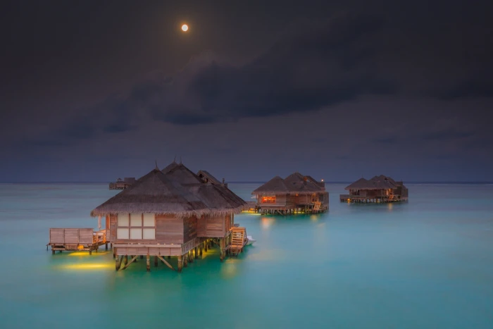 brown and black nipa huts in the middle of ocean illustration 2k