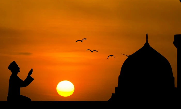 Silhouette of man praying with sunset background islamic prayer 2k