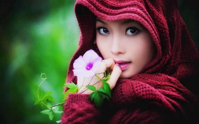 women's red top woman wearing knitted headscarf near pink petaled flower 2k