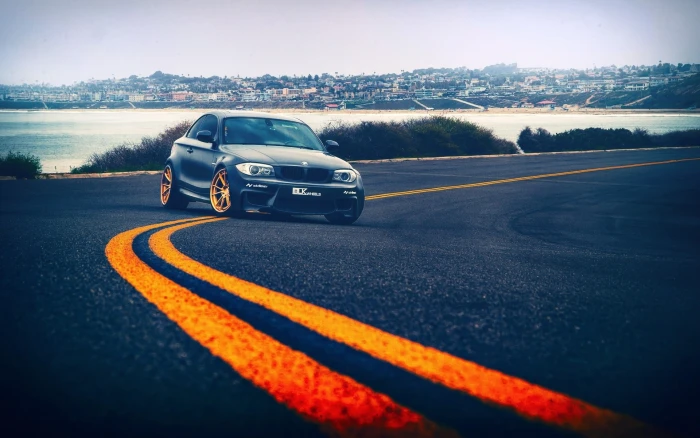 black coupe car road cityscape beach transportation mode of 2k