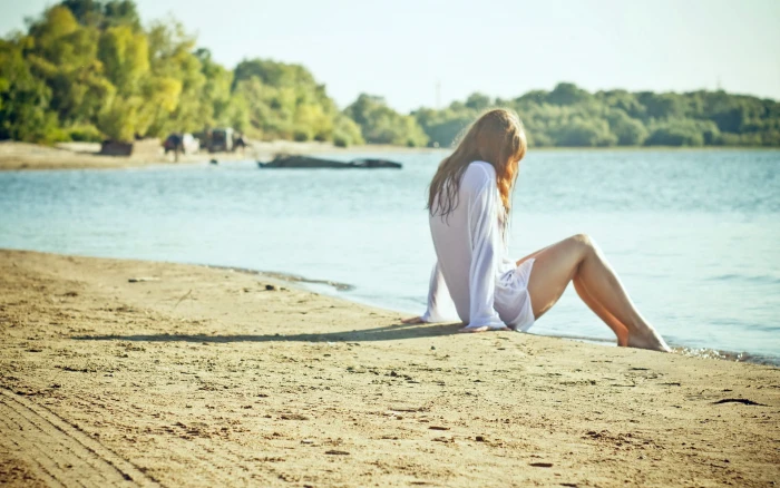 woman wearing white dress shirt sitting on brown sand women 2k