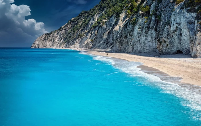 seashore with mountain sand mountains beach water beauty in nature 2k