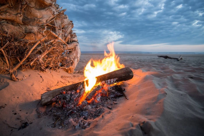 bonfire near sea at golden hour campfire beach heat flame 2k