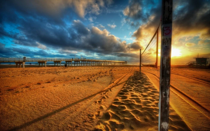 brown wooden post grid beach volleyball decline sand clouds 2k