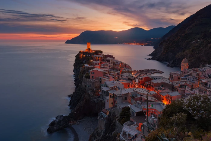 aerial view of village on mountain cliff during orange sunset Santorini Greece 2k