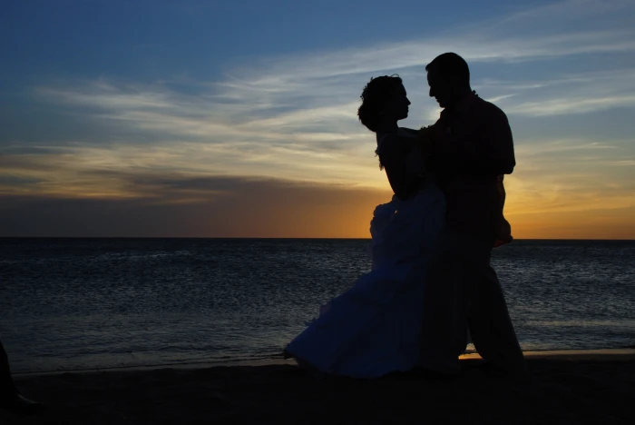 silhouette of dancing man and woman on shore during sunset couple 2k 4k