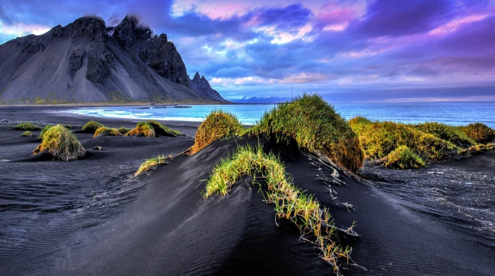 black sand beach Iceland sea mountains cliff grass clouds 2k