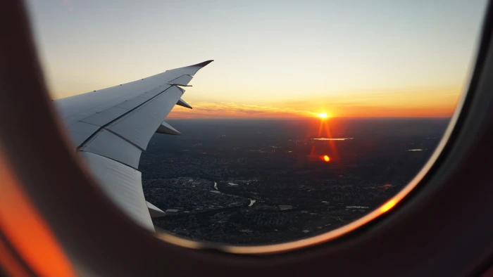 airplanes window view of sky during golden hour person s airplane clear skies above city 2k 4k 5k