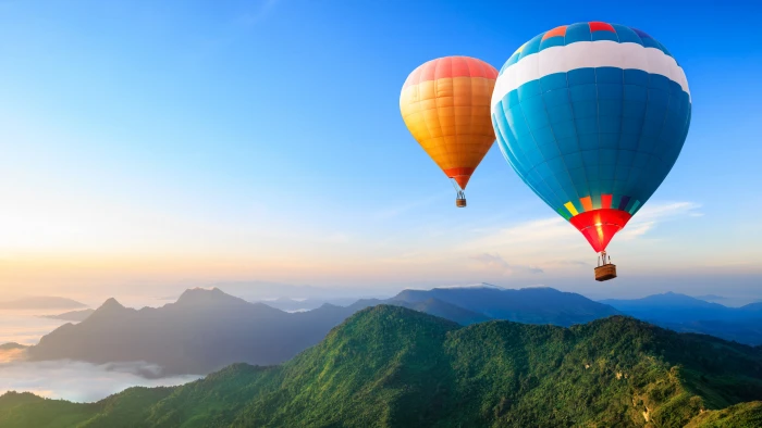 blue and white hot air balloon illustration two orange balloons airborn over mountains 2k 4k
