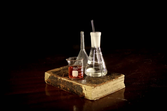 three assorted measuring bottles on brown hardbound book Pharmacy 2k 4k 5k