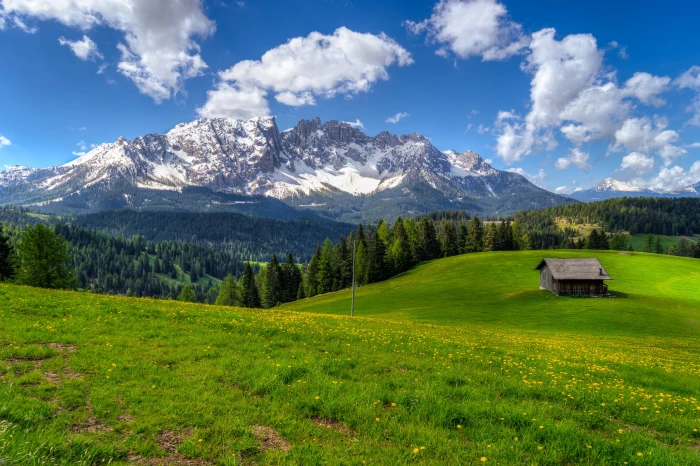 landscape photography of house surrounded with green grass snowy mountain during daytime italy latemar 2k