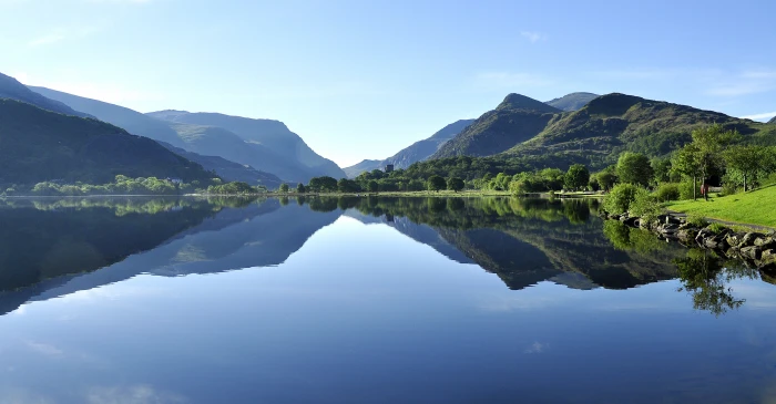 landscape photography of lake near green leaf trees under clear sky 2k 4k