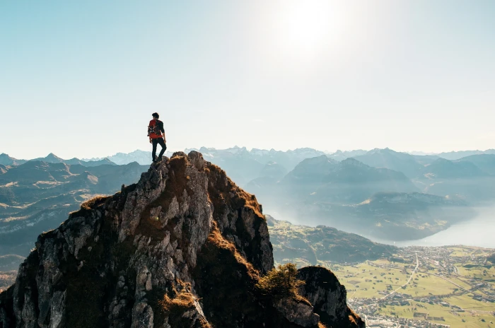 person standing on top of mountain nature water mountains 2k 4k