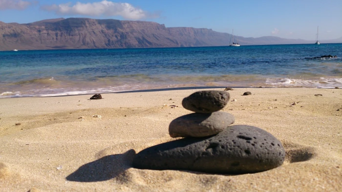 three gray pebbles beach stones Lanzarote sea land water 2k 4k