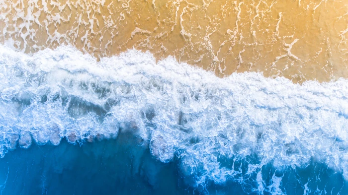 bird s eyeview of seashore blue ocean wave towards the shore 2k 4k