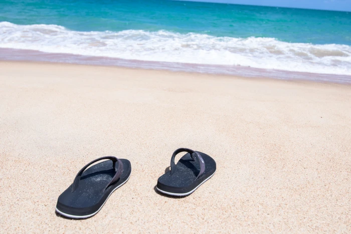pair of black flip flops in seashore beach amazing andaman sea 2k 4k 5k