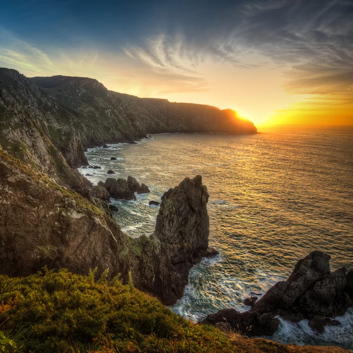 rock formations on seashore during gold hour galicia 2k 4k