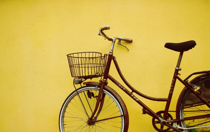 female beach cruiser bike leaning on yellow painted wall brown park beside 2k 4k 5k