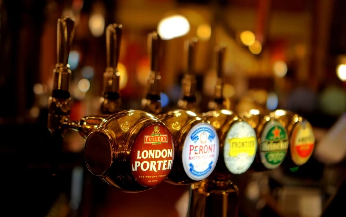 assorted beer tap handles macro bars focus on foreground text 2k