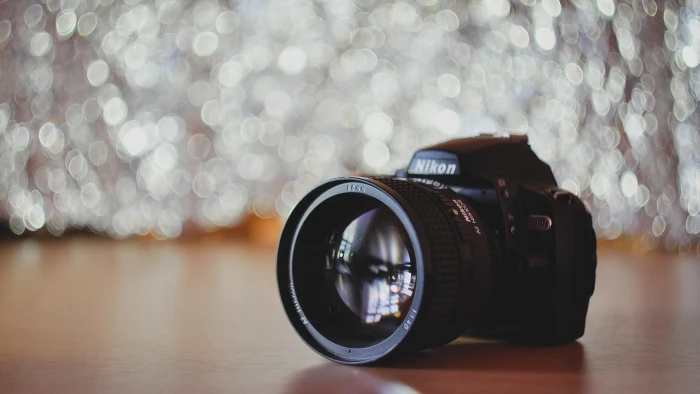 black Nikon DSLR camera lens bokeh wooden surface Photographic Equipment 2k