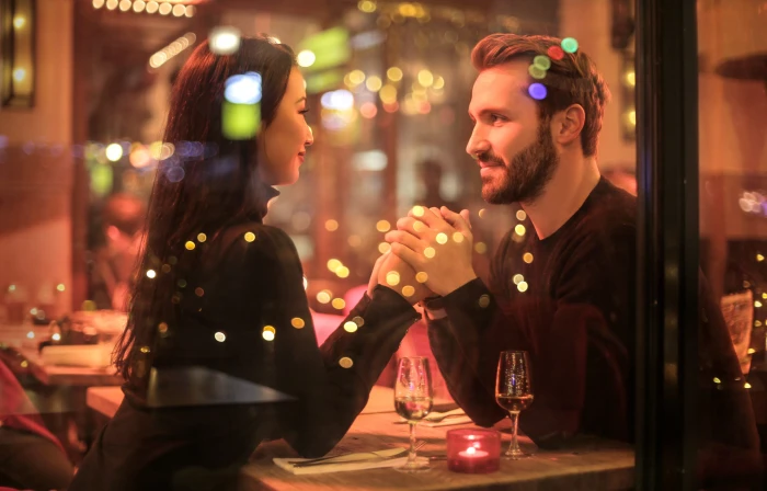 Romantic couple holding hands together over candlelight during romantic dinner 2k