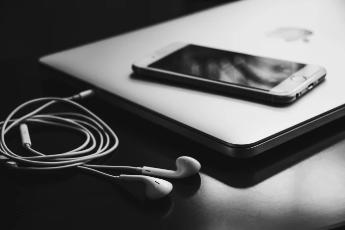 white in ear earphones on black wooden table macbook air gold 2k 4k 5k