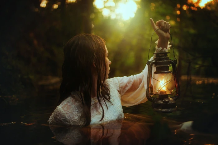 women s white long sleeved top close up of woman carrying lantern 2k