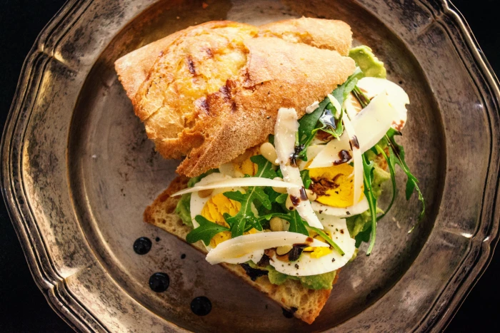 toasted bread with sliced egg and fresh vegetables on copper colored plate 2k 4k 5k