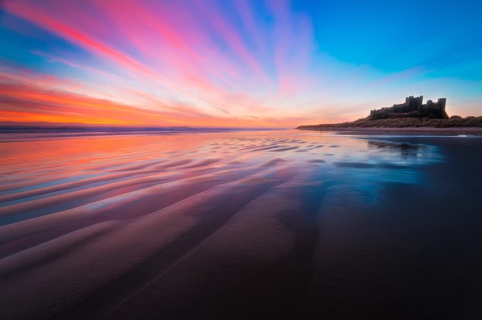 body of calm water at sunset Bamburgh Castle Sunrise england 2k 4k 5k