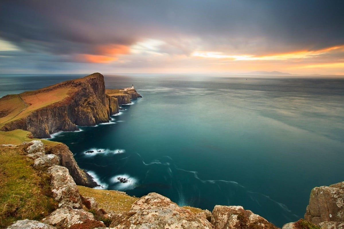 aerial photography of cliff overlooking sea during golden hour