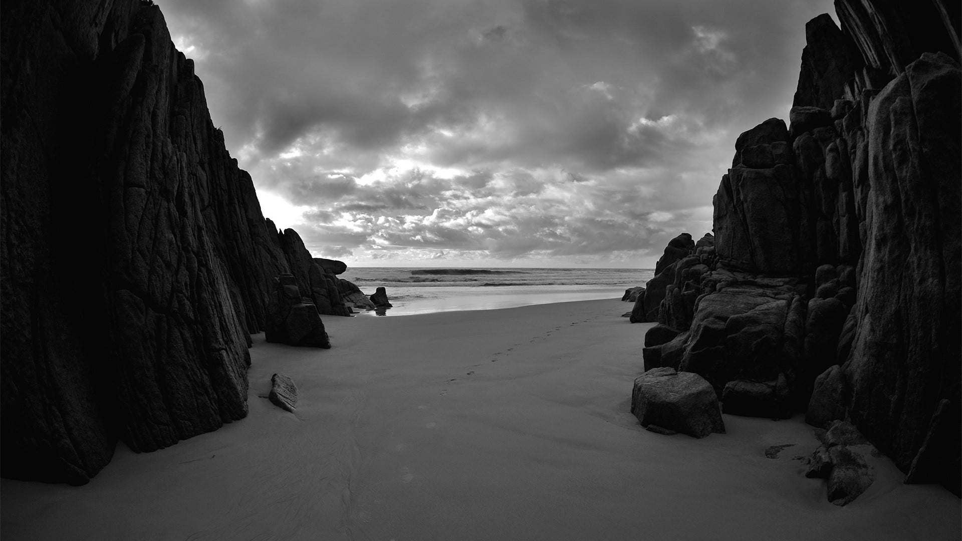 rocky cliff landscape beach monochrome clouds sky sea water 2k