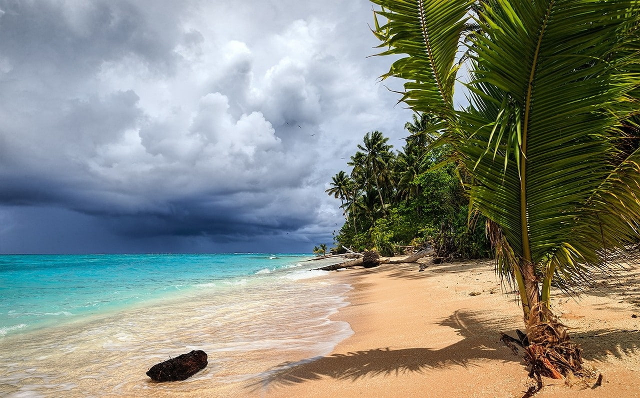 storm tropical beach sea sand palm trees atolls clouds
