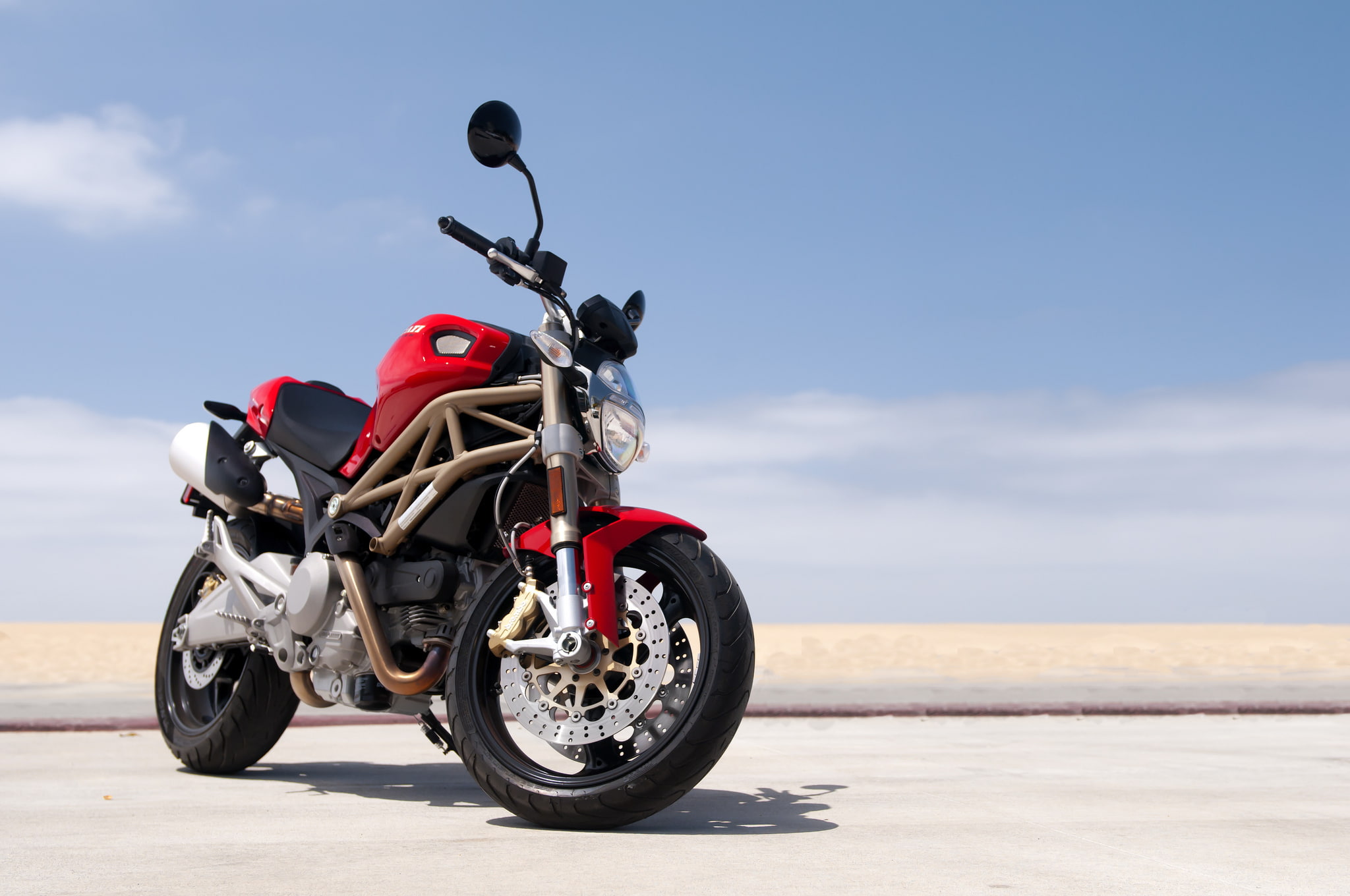 red Ducati Monster beach road sky 2k