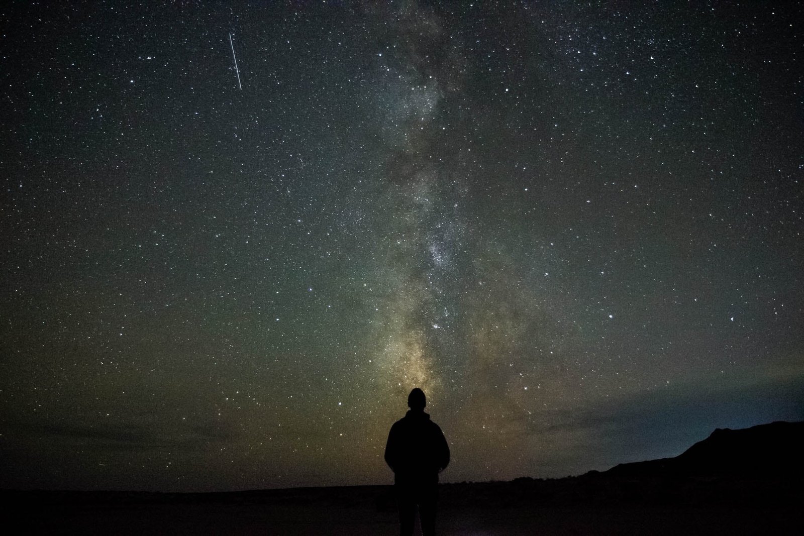 man on top of mountain person standing looking stars galaxy 2k