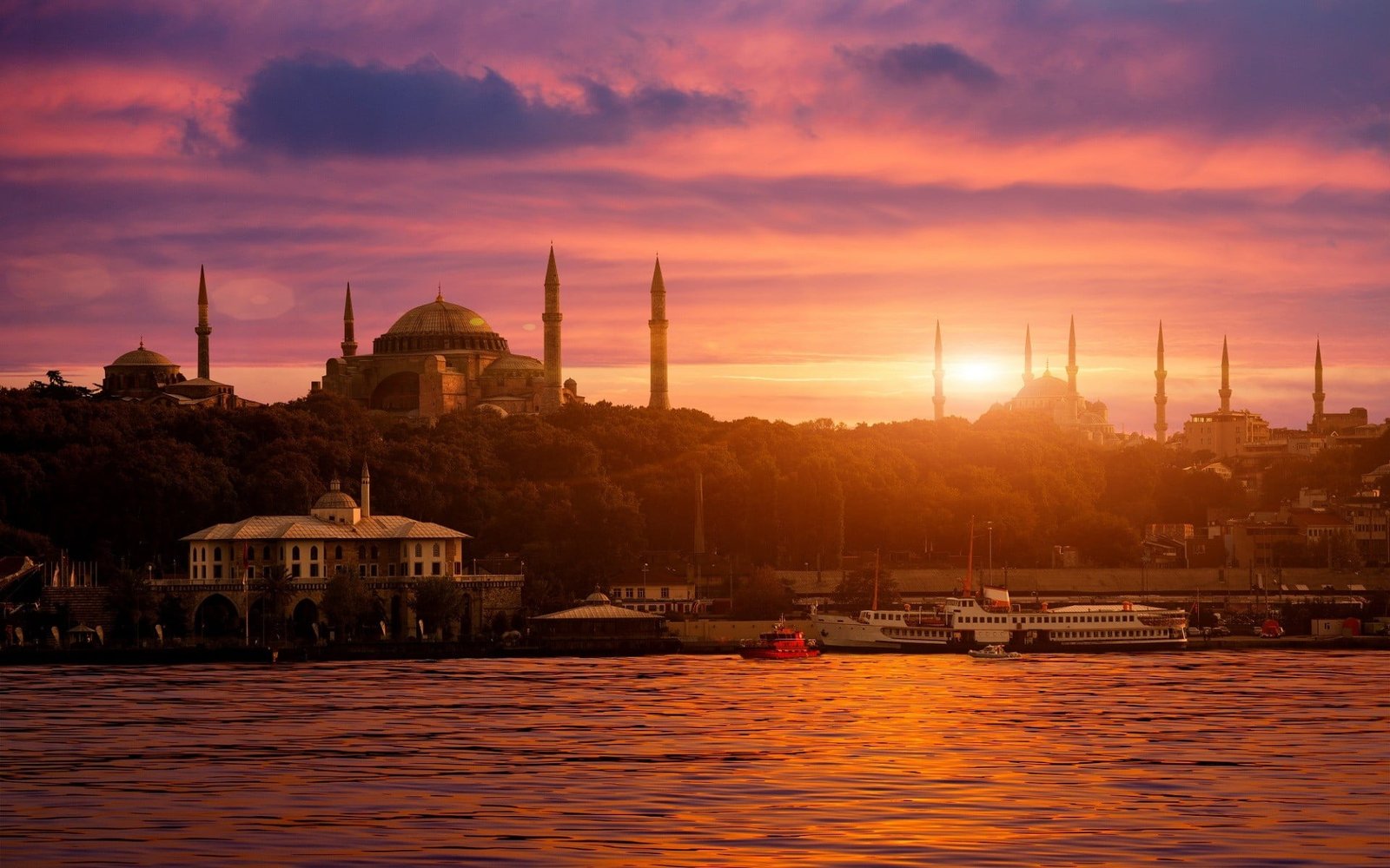 mosques near buildings and body of water during golden hours 2k