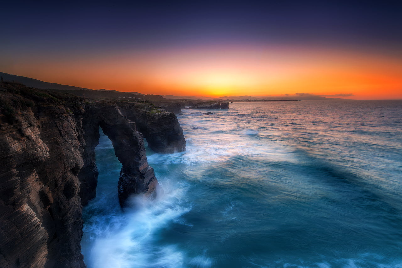 time lapse photography of rocky mountain with splash sea landscape