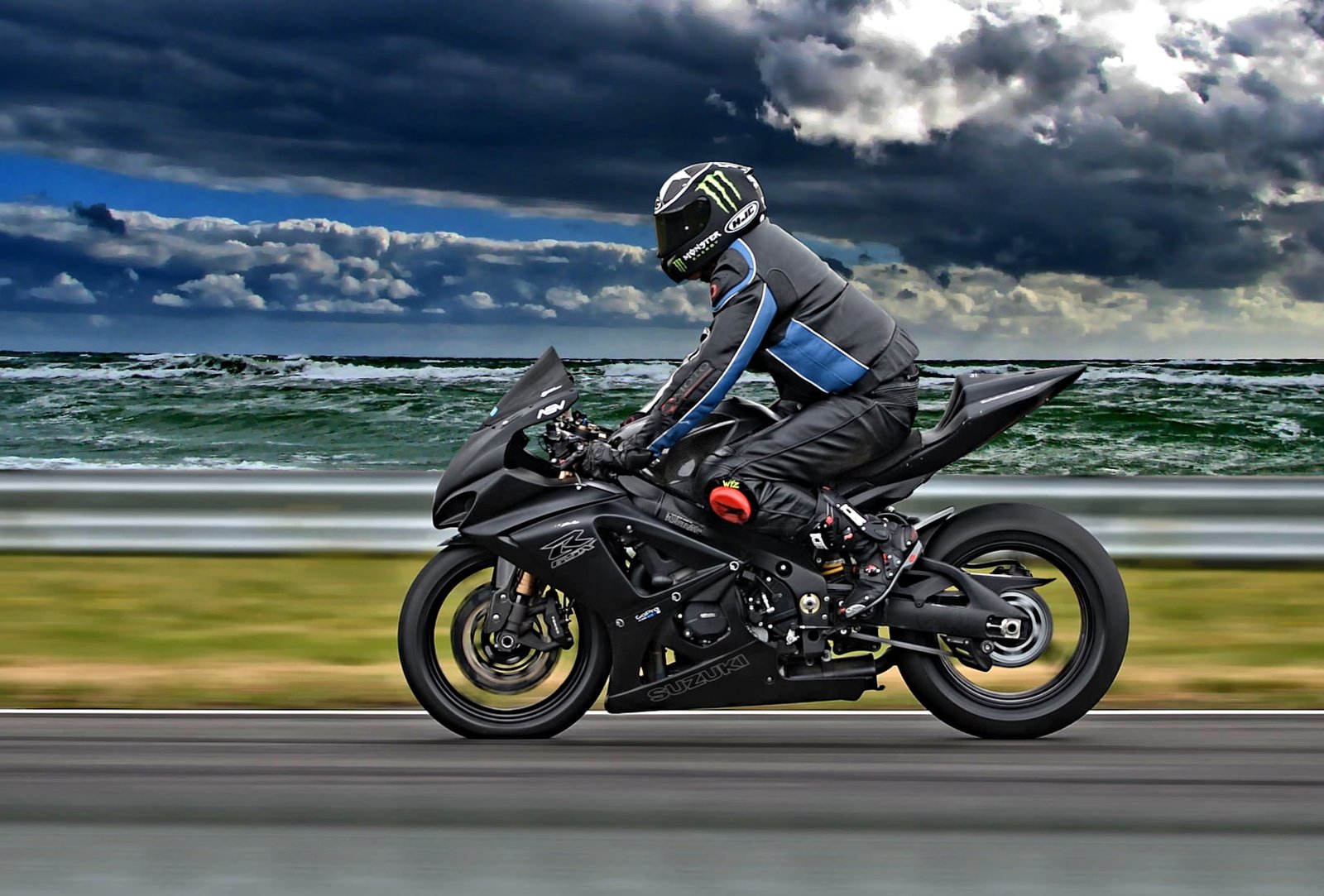 man riding motorcycle on road near beach SUZUKI 2k