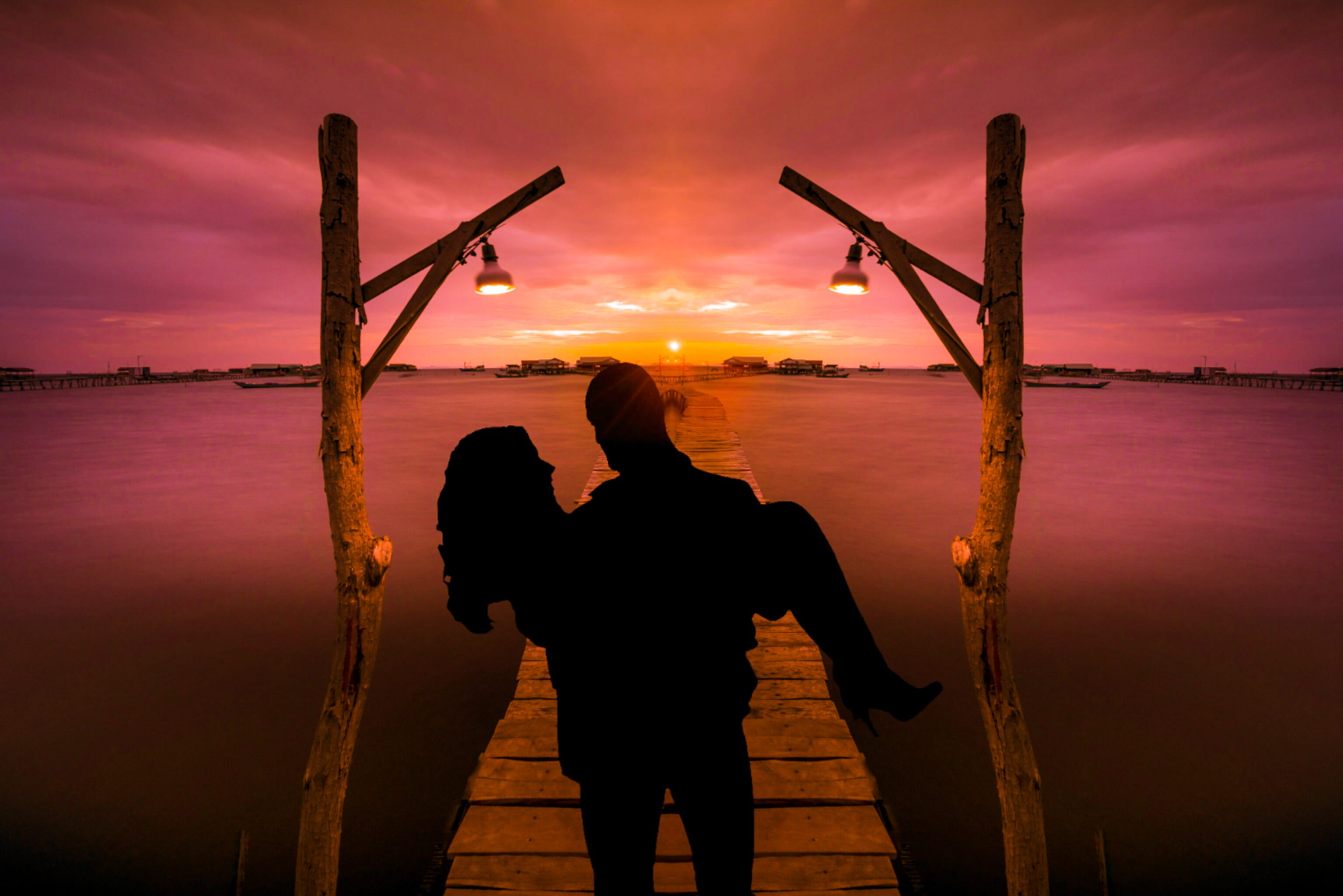silhouette of man carrying woman on dock near water face to 2k
