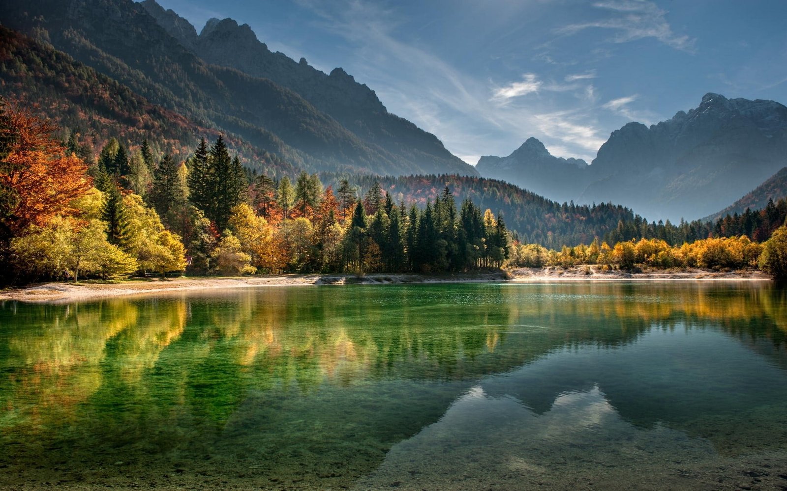 body of water calm surrounded with trees and mountains 1 2k