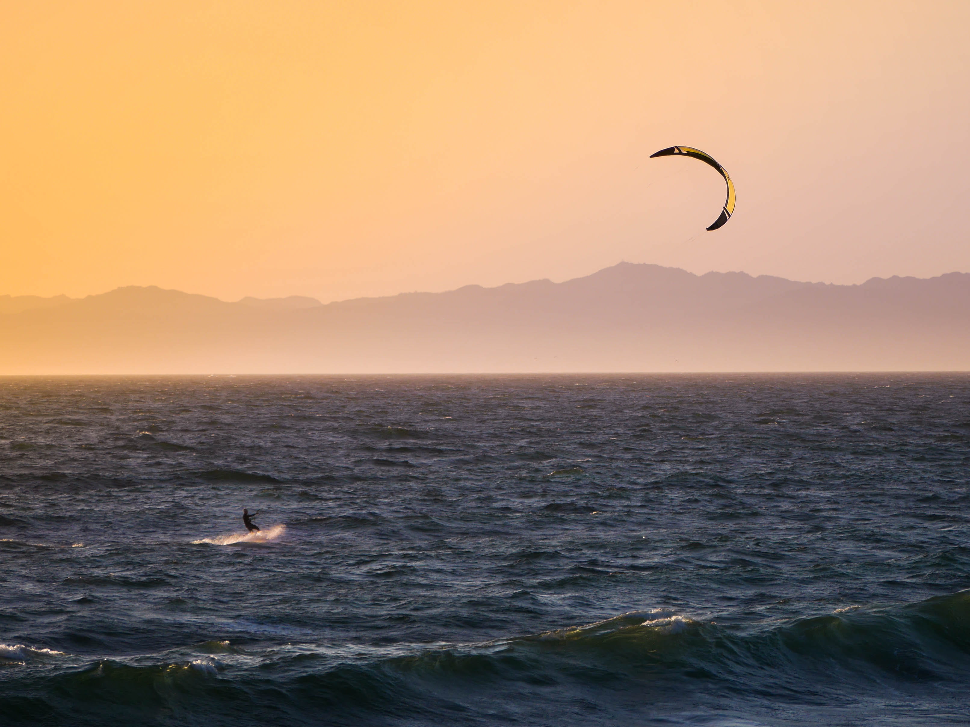 kitesurfing during golden hour person kite surfing at sunset 2k