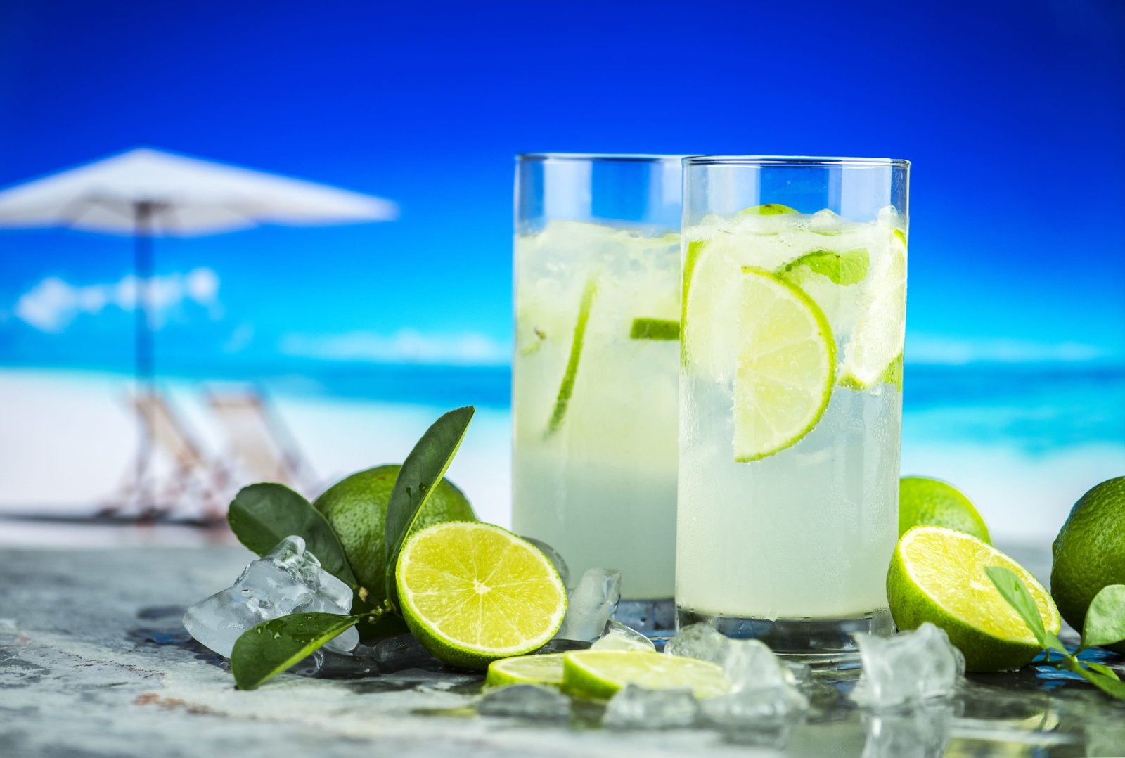 two clear drinking glass with liquid and lime fruits beach beverage 2k 4k