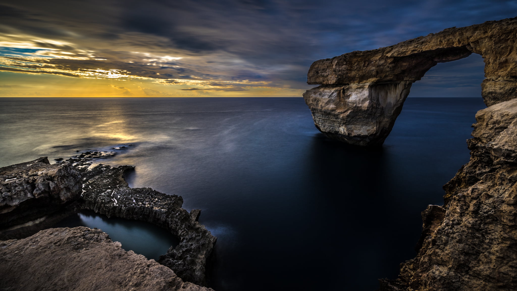 brown and black stone formation on water Azure Window Gozo 2k
