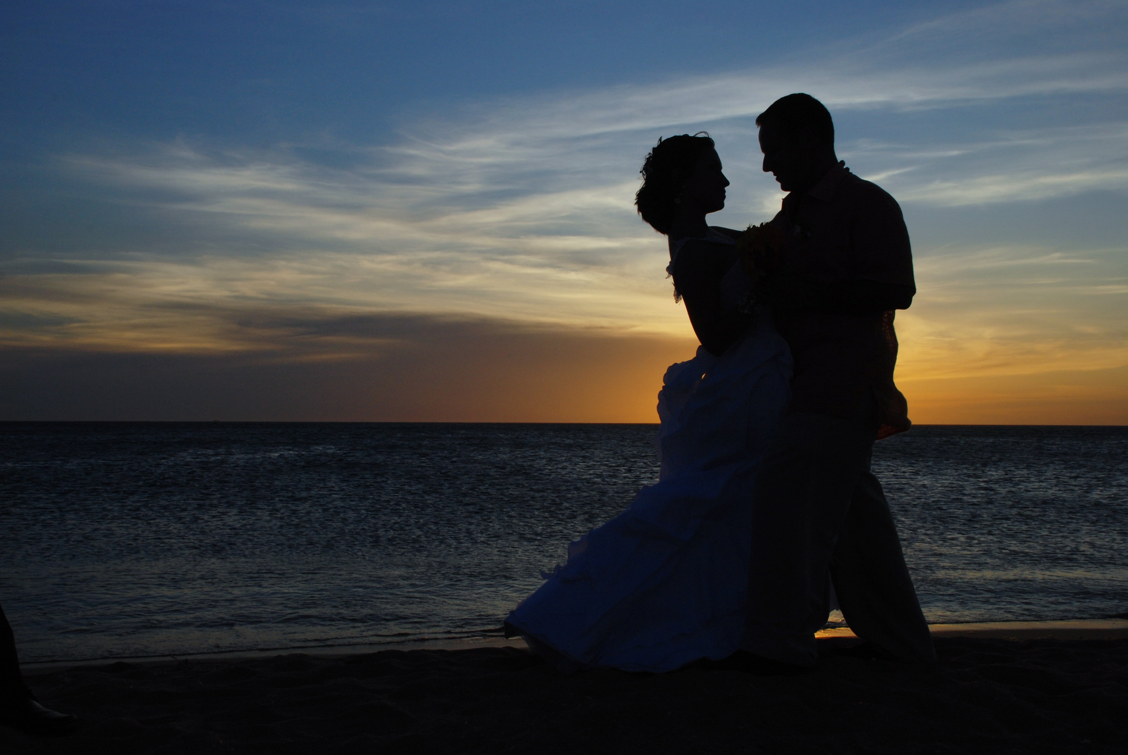 silhouette of dancing man and woman on shore during sunset couple 2k 4k