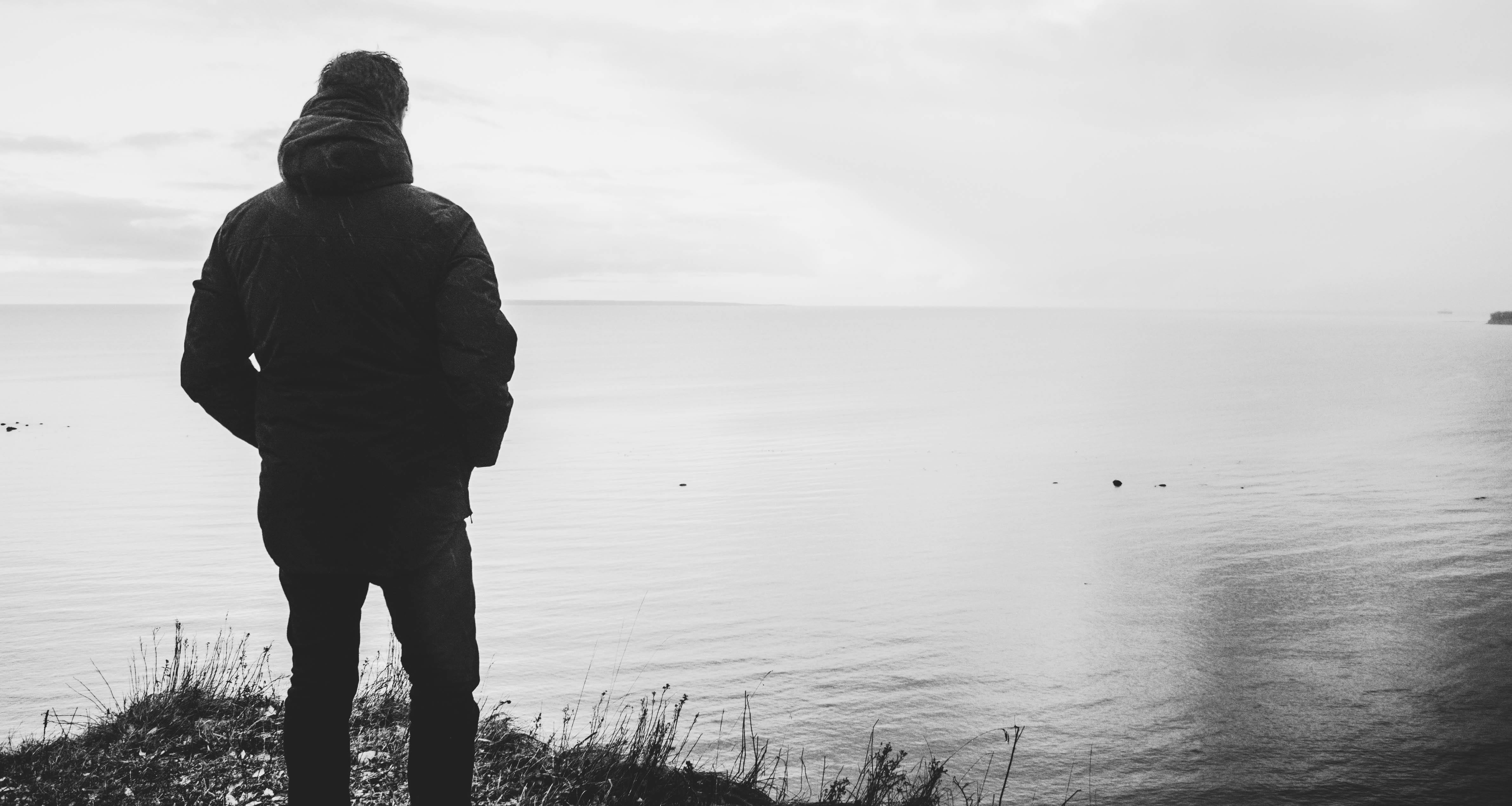 Silhouette of Man Standing Near Body Water alone beach black and white 2k 4k 5k