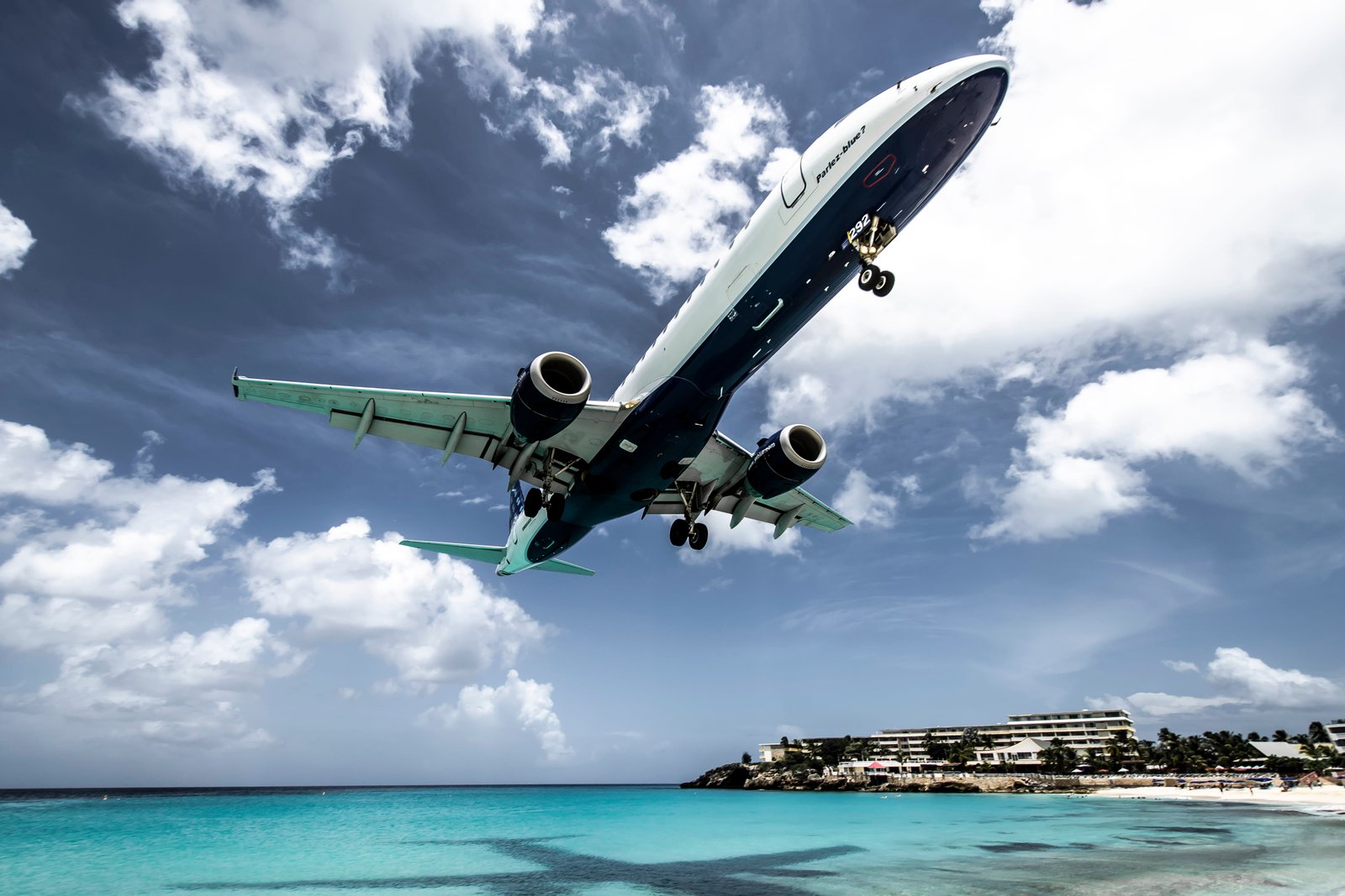 white aircraft above beach shoreline at daytime airplane transportation 2k 4k