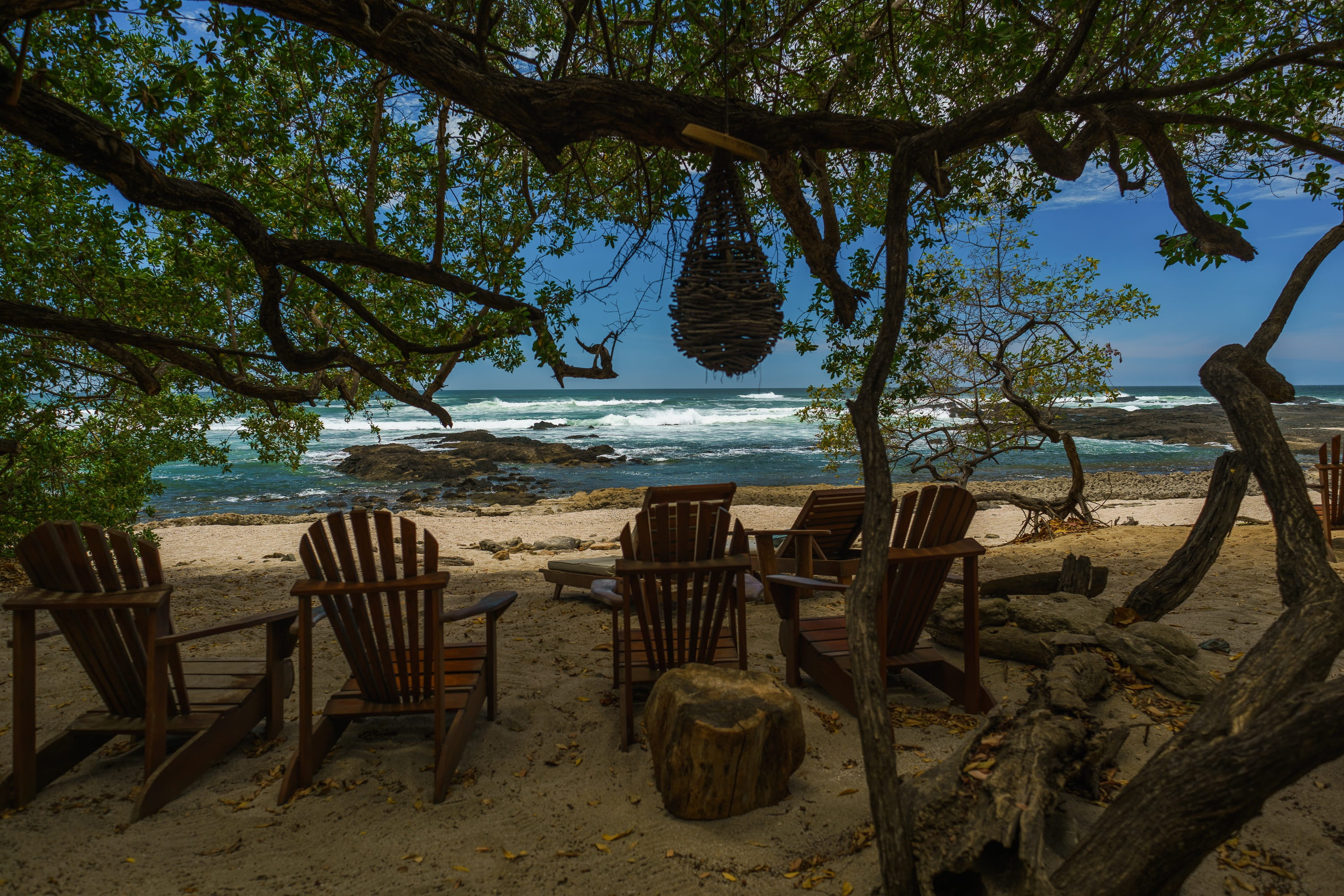 empty brown Adirondack chairs under tree Beach Tropical Costa Rica 2k