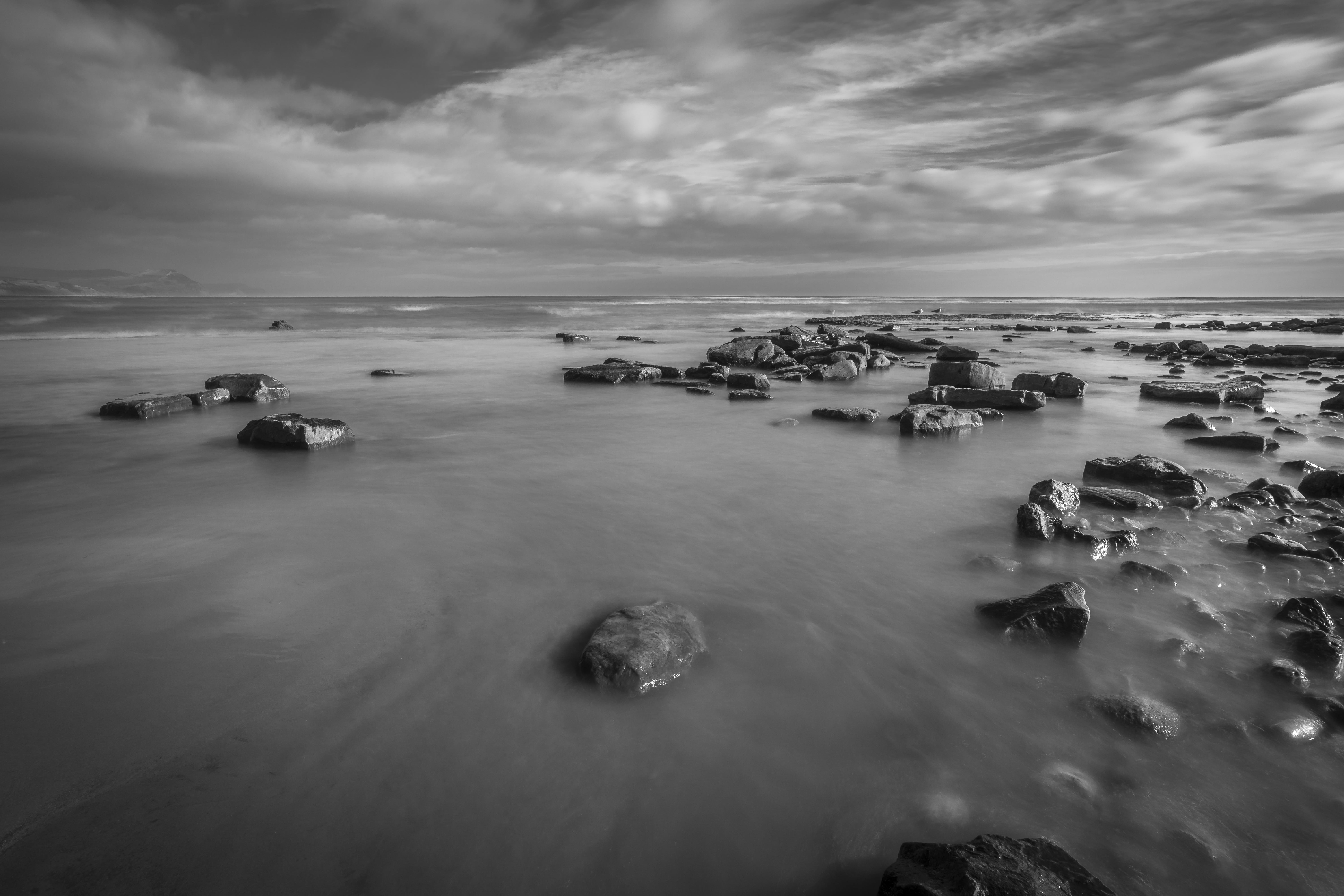 gray scale photo of beach with rocks Long Exposure Lyme Regis 2k 4k 5k