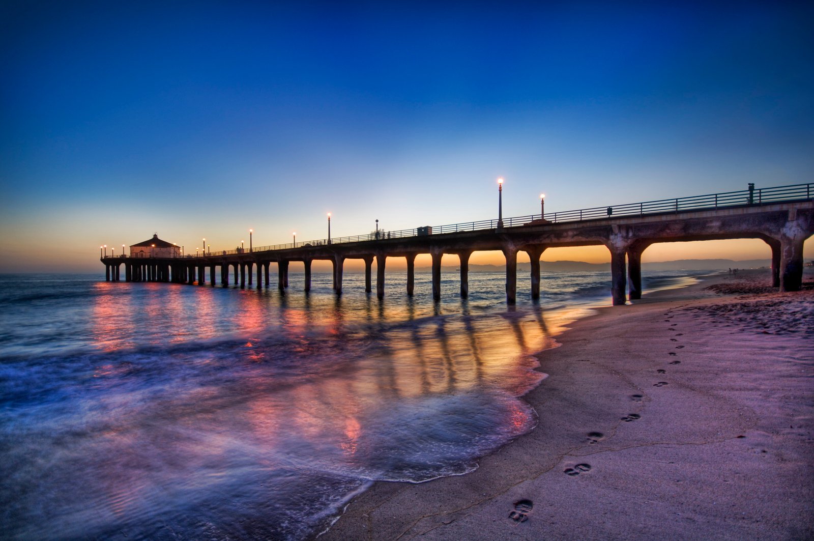 grey foot bridge beside bodies of water Footprints Blue Sunset 2k 4k