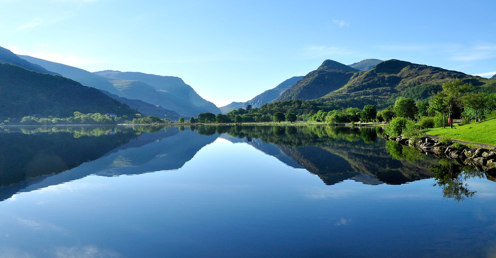 landscape photography of lake near green leaf trees under clear sky 2k 4k